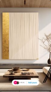 יצירת אמנות בעבודת יד בשיטת Fabric Art – שילוב של בד רך בגוון קרם עם פס זהוב יוקרתי. מעניקה לחלל תחושת רוגע, חמימות ואלגנטיות טבעית